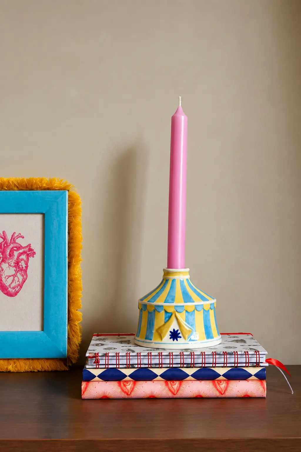Kitsch Royale kandelaar met roze kaars naast een fotolijst